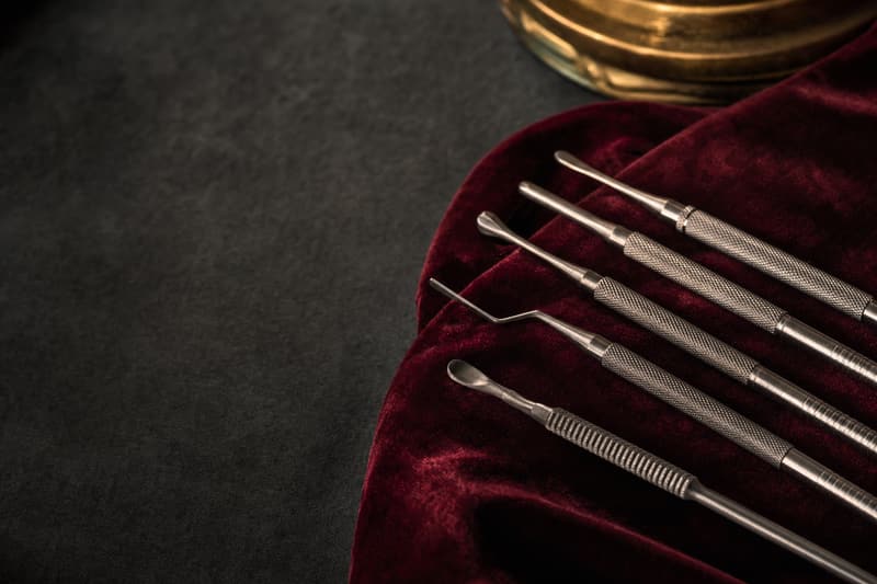 Instrumentos finos de aço alinhados sobre veludo bordô